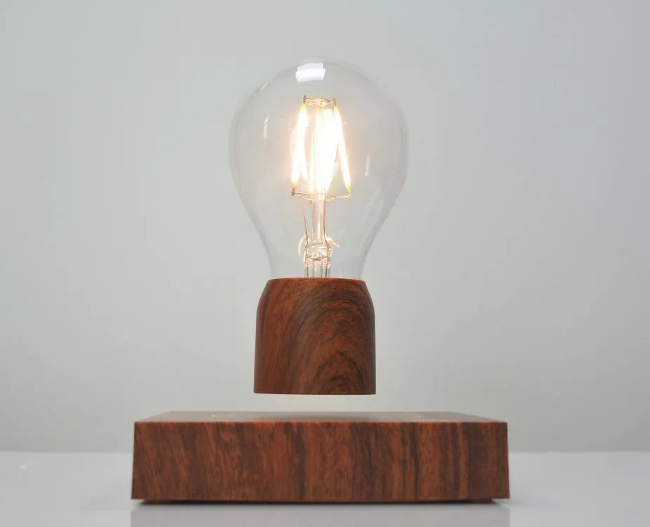 Magnetic levitation light bulb floating above its imitation wood base.