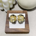Pearl flower shaped metal earrings in red and white colour options on a grey background