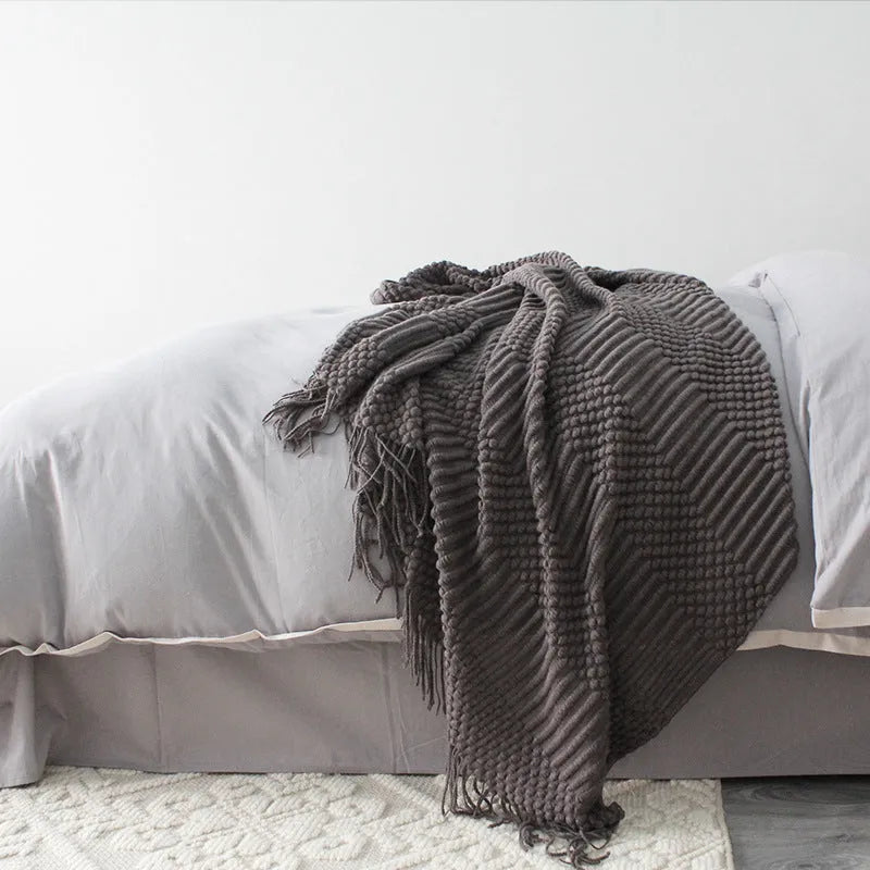 Small light grey polyester throw blanket folded, showing its rectangular 127cm by 170cm size.