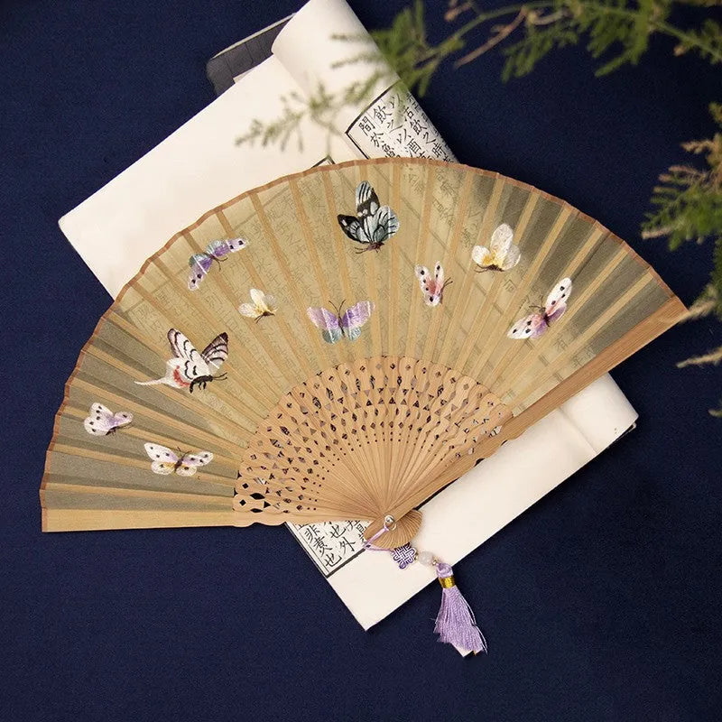 Bamboo frame silk embroidered folding fan showing intricate traditional patterns with folded and open positions