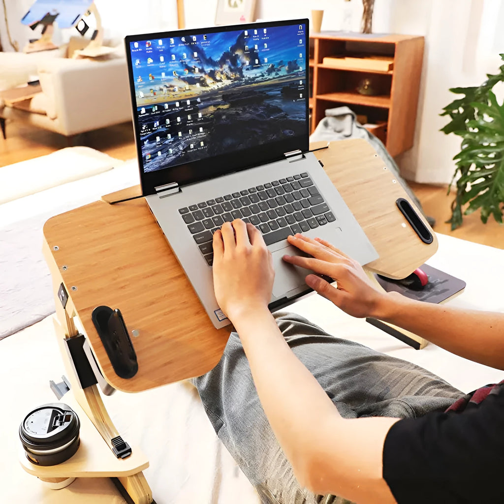 White maple wooden folding computer desk with adjustable angle, shown on a bed.