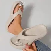 A pair of women's thick-soled flip-flops in grey, showing the EVA material and non-slip footbed texture.