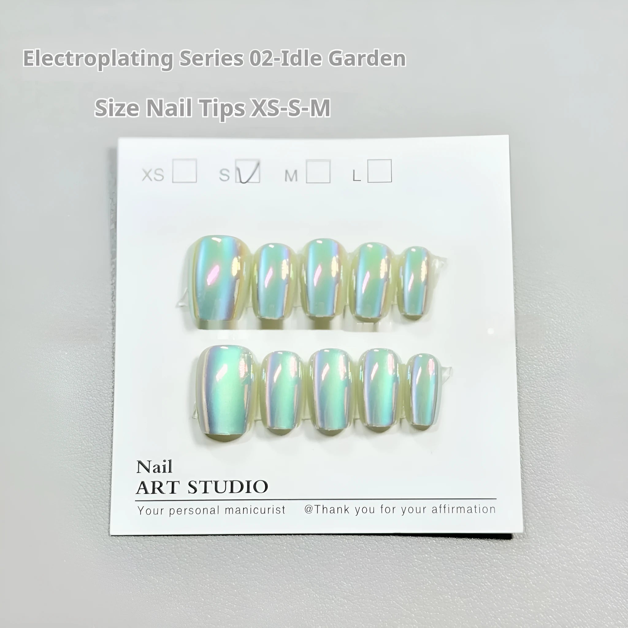 Set of electroplated Cat's Eye false nails in short ladder lengths on a clear stand.