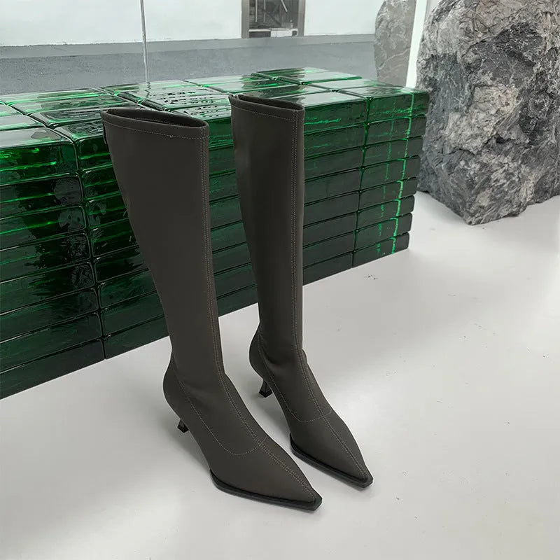 Women's black below the knee boots with pointed toe and stiletto heel, back zipper closure visible