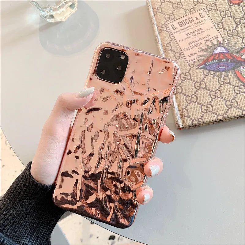 Rose gold and silver folded TPU back cover cases for various iPhone models on a plain surface.