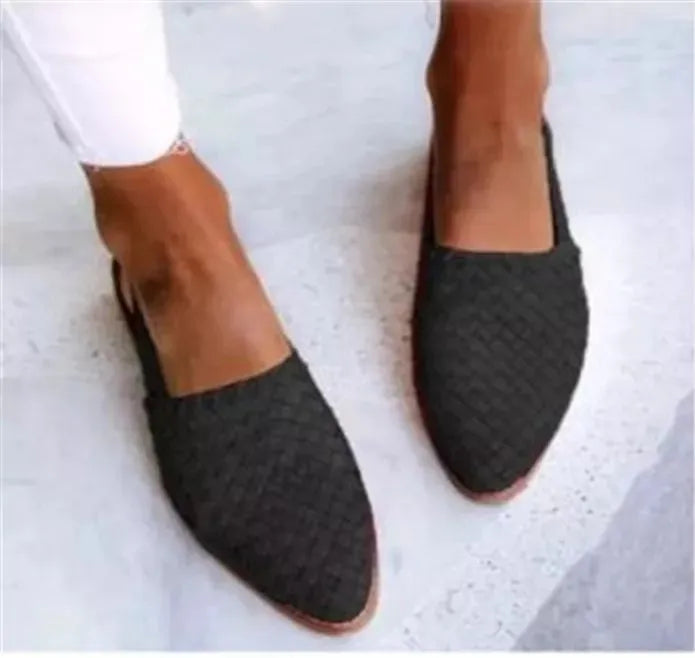 Women's black flat sandals with a buckle fastening and pointed toe on a rubber sole.