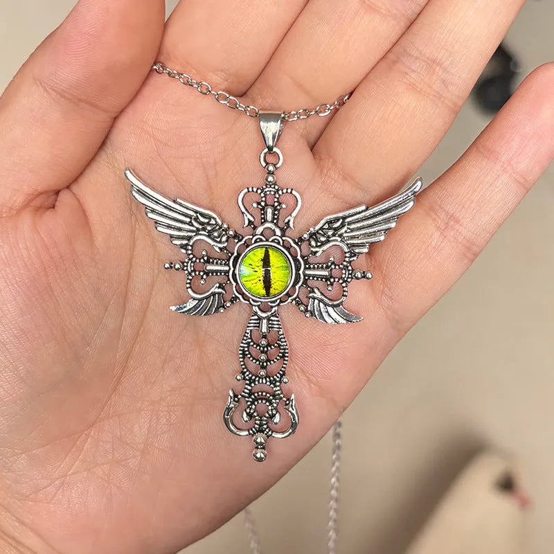 Close-up of a devil wings and cross design alloy pendant necklace on a chain, shown in a choice of colours.