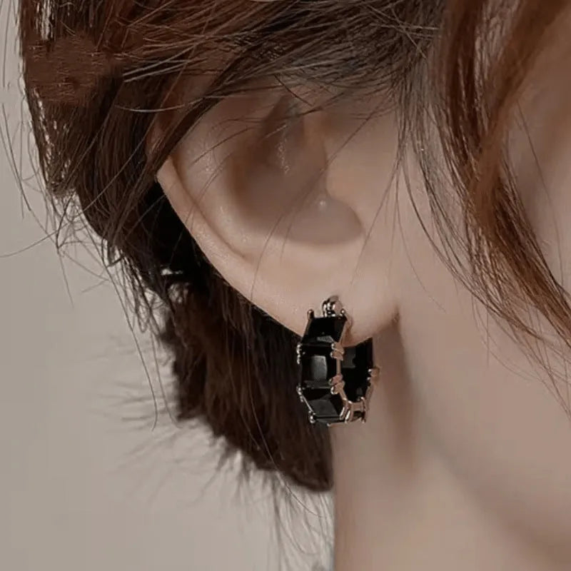 Gold geometric U-shaped women's earrings with a round black crystal zirconium stone.