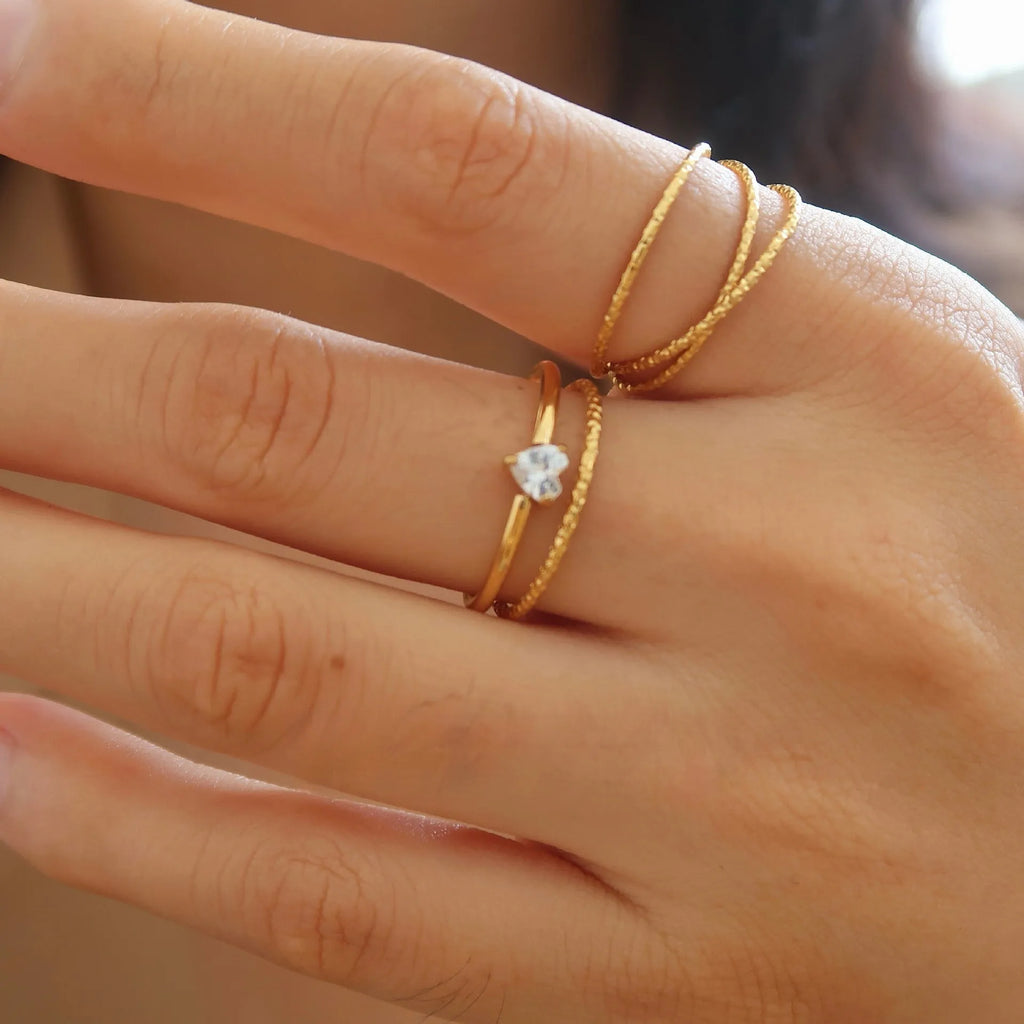 Golden electroplated stainless steel ring with love heart design, shown in sizes 5 to 8.
