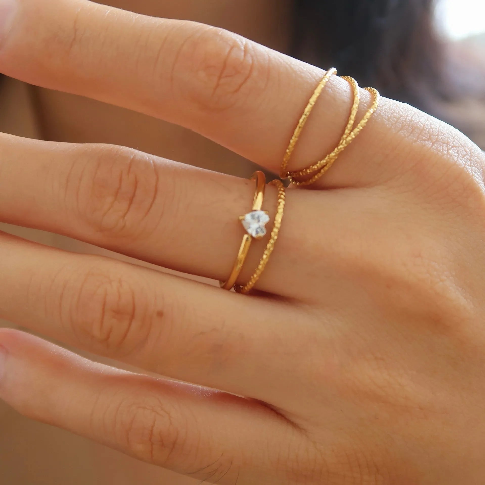 Golden electroplated stainless steel ring with love heart design, shown in sizes 5 to 8.