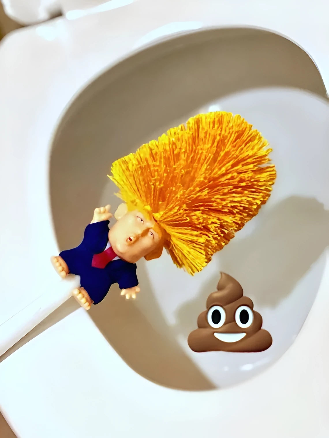 Yellow plastic Donald Trump toilet brush with hanging slot on handle.