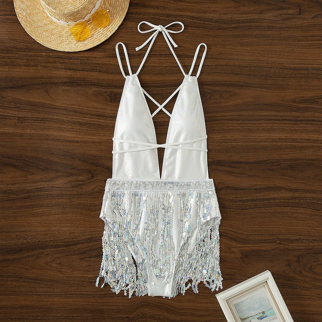 White one-piece swimsuit with deep V-neck and tassel detail on a mannequin