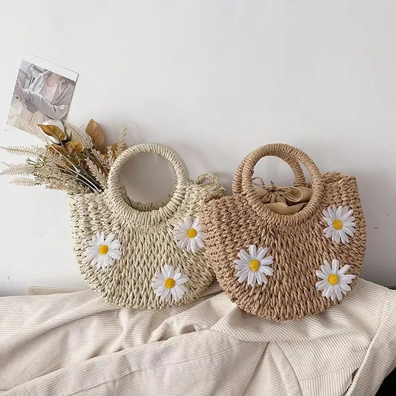 Light brown straw weave crossbody bag with daisy accents and adjustable strap