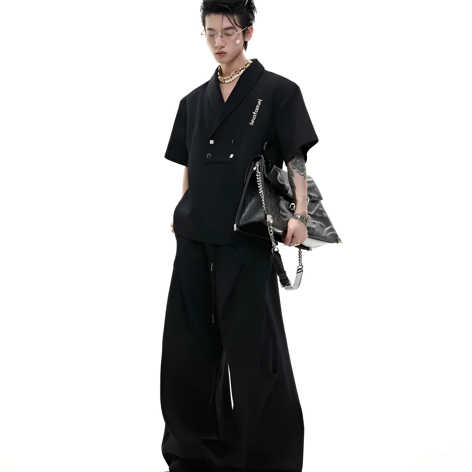 Men's dark grey cotton sports suit with V-neck top featuring padded shoulders and metal embellishments, paired with matching shorts.