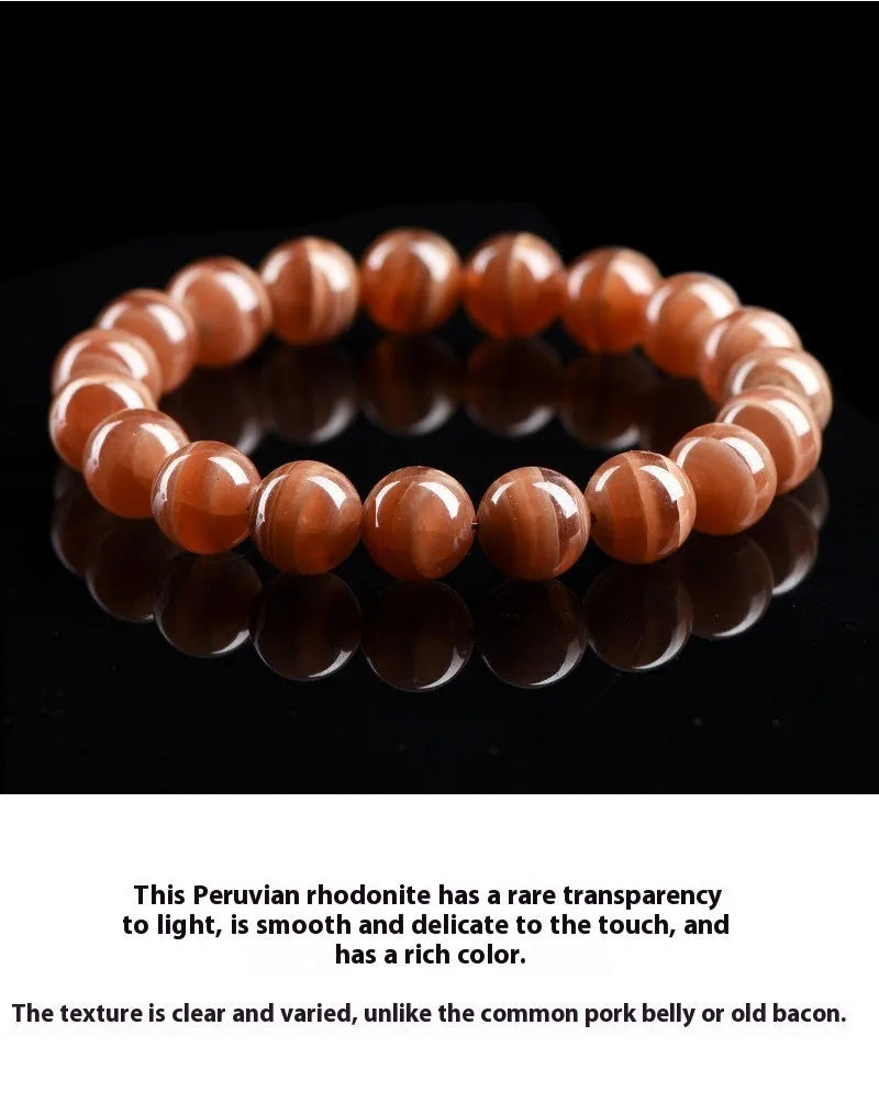 Natural old mine rhodochrosite round bead bracelet with Ruyi detail on a wrist.