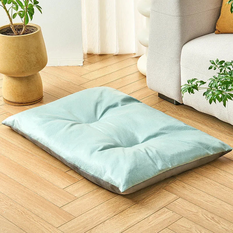 Blue plush fabric pet sleeping mat for cats or small dogs shown in a home setting.
