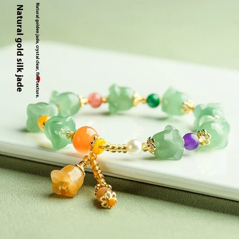 Natural Jinsi Jade bracelet with carved orchid beads on a wrist.