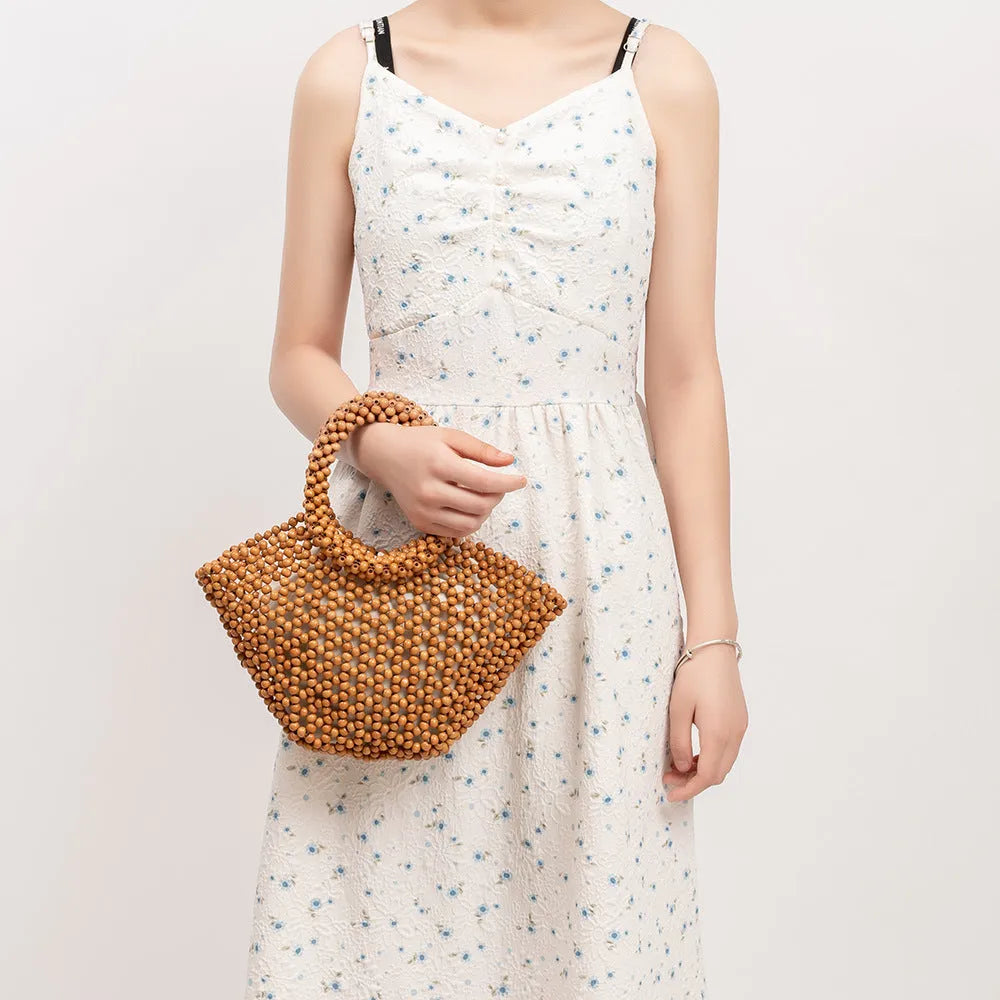 Hand-woven dumpling-shaped handbag with wooden beads in milky white colour