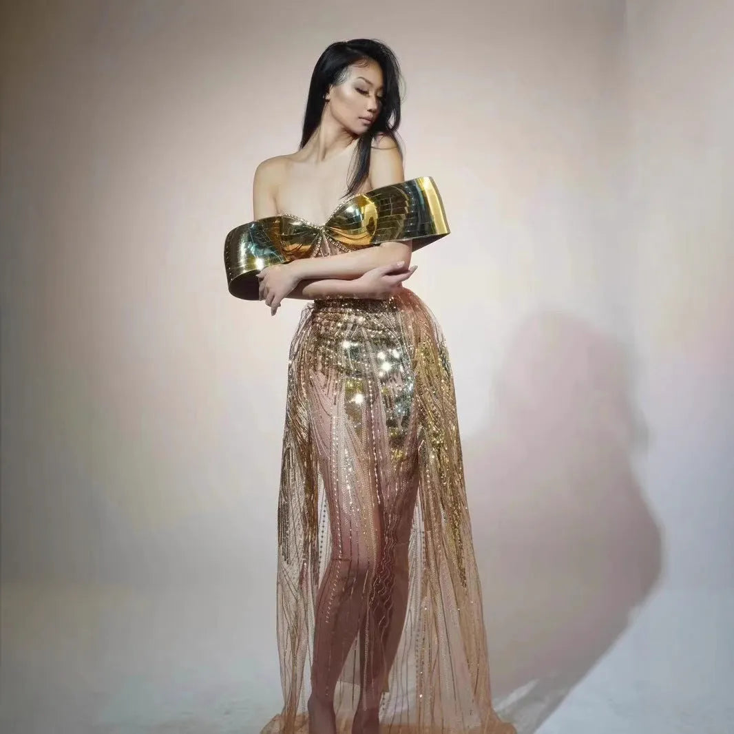 Gold metallic strapless dress with sequin details and a full tulle skirt featuring a high split.