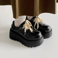 Matte black women's lace-up shoes with a chunky English muffin heel and thick rubber sole.