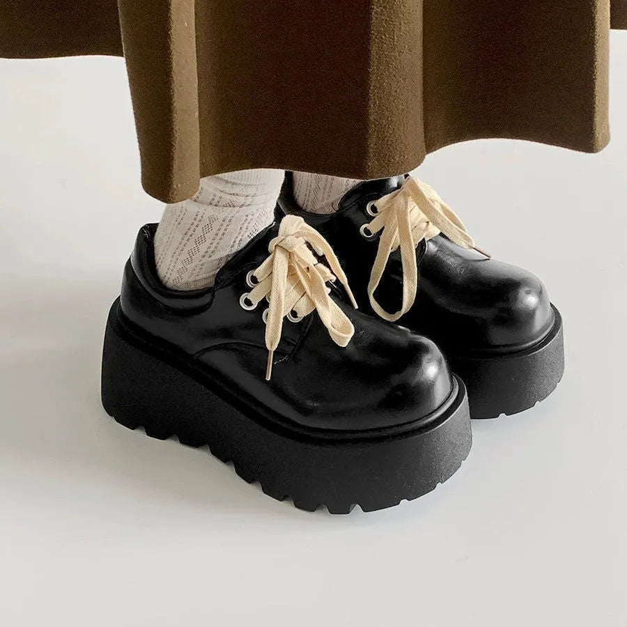 Matte black women's lace-up shoes with a chunky English muffin heel and thick rubber sole.