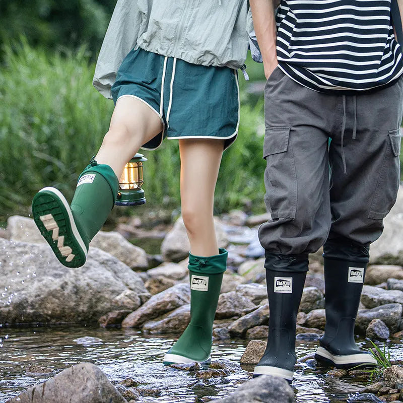 Pair of solid colour high tube PVC rain boots with a low heel on a non-slip sole.