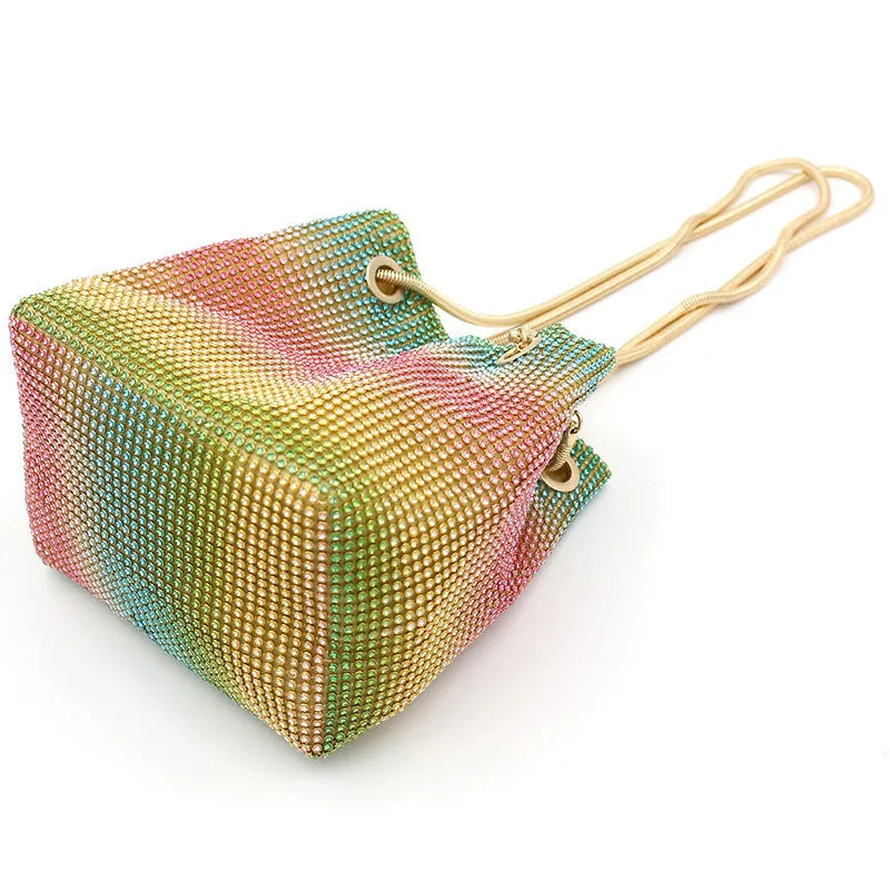 Rainbow coloured rhinestone bucket bag with an adjustable metal chain strap.