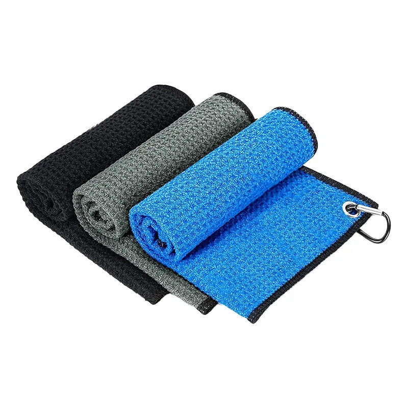 Waffle weave golf ball cleaning towel in blue, shown next to a golf ball.