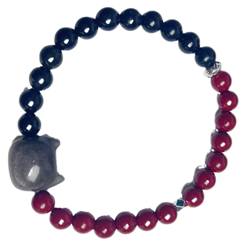 Black obsidian cat bracelet with golden crown charm and red bead on elastic cord