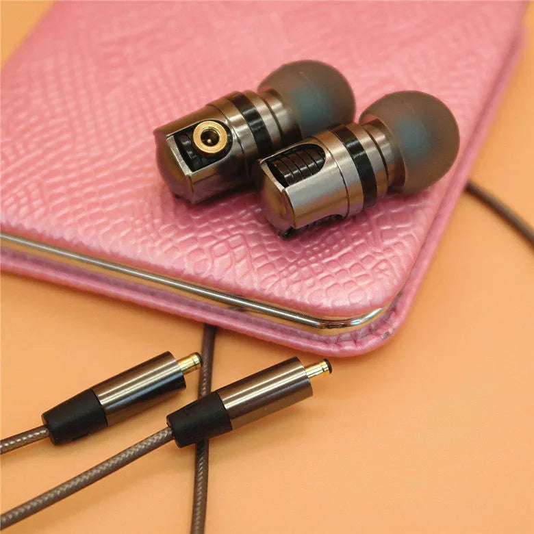 Titanium grey metal in-ear earphones with a detachable cable on a grey background.