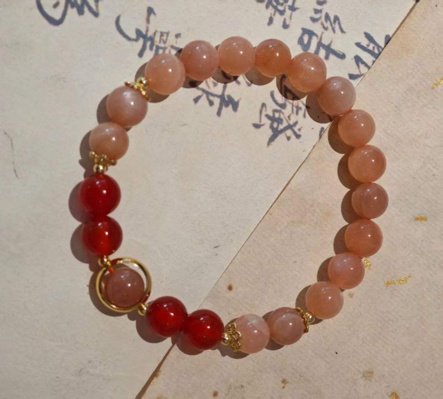 Handmade red agate and sunstone bracelet with carved xiangyun ethnic motifs, 8mm bead diameter