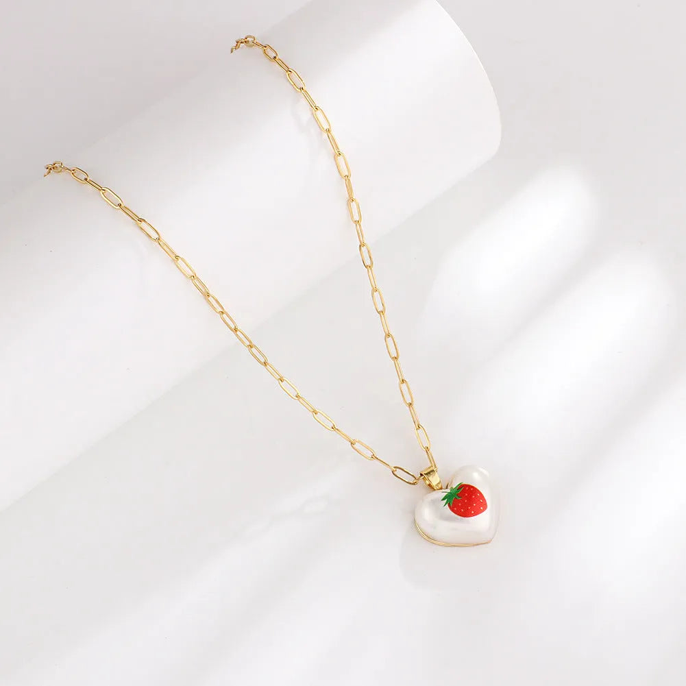 Heart-shaped necklace with geometric chain and a detailed fruit pendant charm, adjustable from 21cm to 50cm.