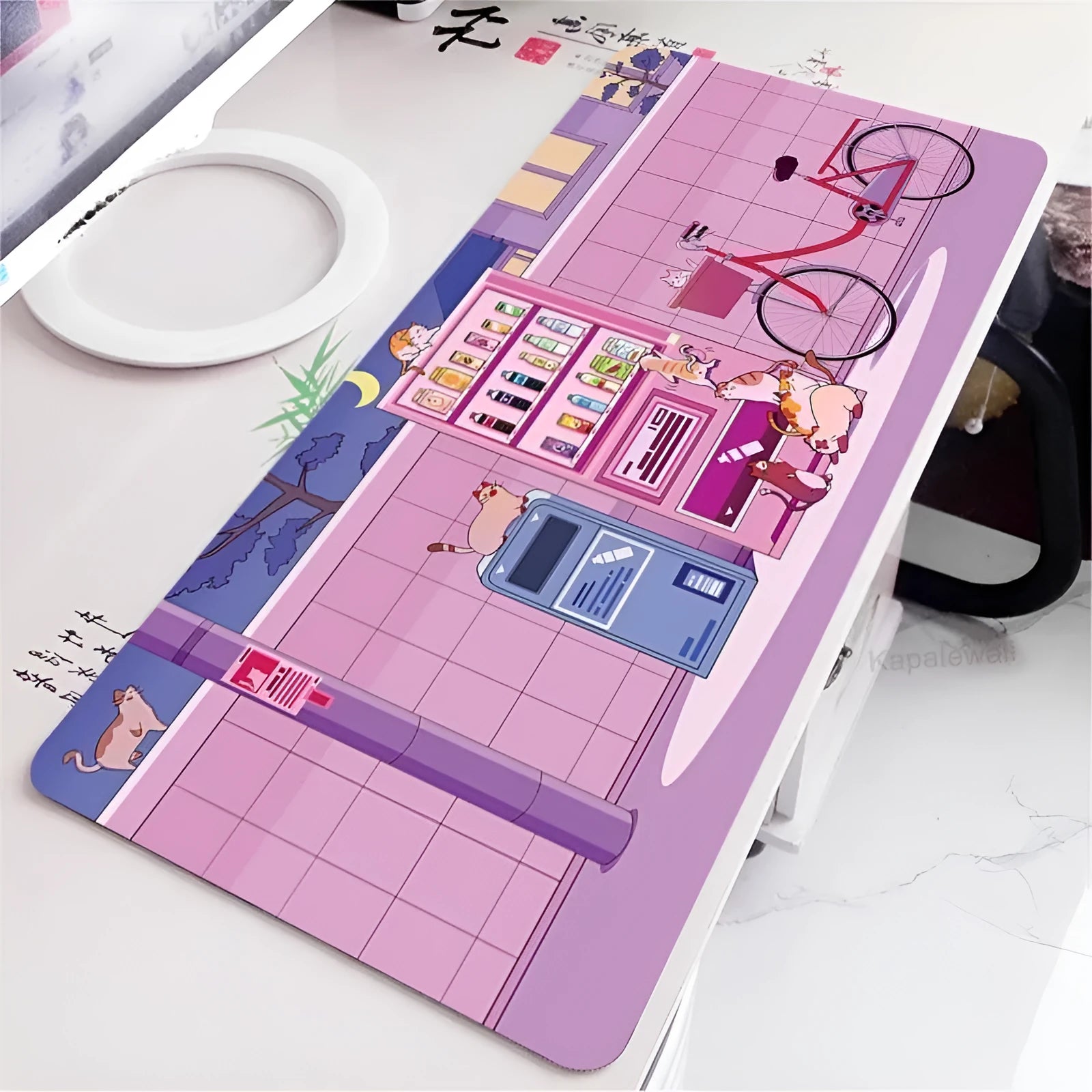Oversized cat head design desk mat on a table, showing its large surface area and 3mm rubber edge.