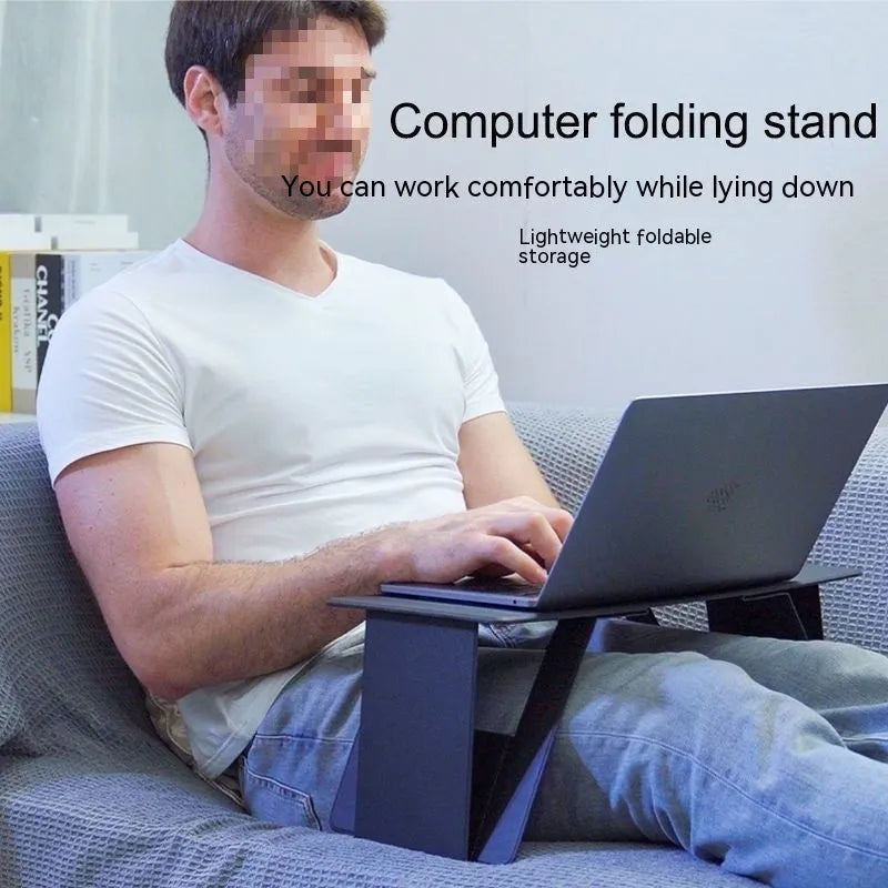 Foldable wooden laptop stand in black with storage area and folded legs on a flat surface