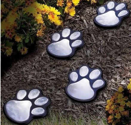 Four black paw print solar garden lights connected to central solar panel pole