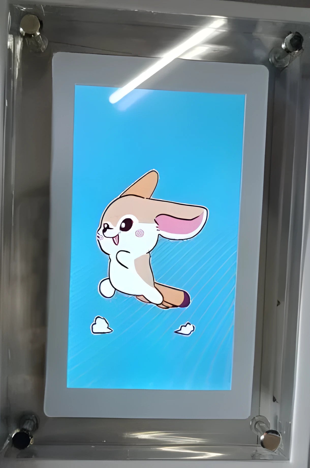 White vertical digital picture frame with acrylic casing on a table, showing a family photo on screen.