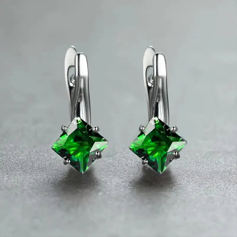 A pair of copper diamond-shaped earrings with inlaid zircon stones, shown in blue, green, and colour variants.