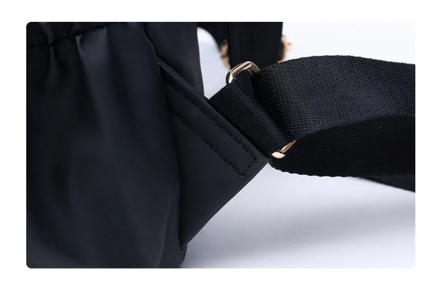 Black waterproof Oxford cloth backpack for women, 34x26x13cm, with two straps and front pocket on plain background