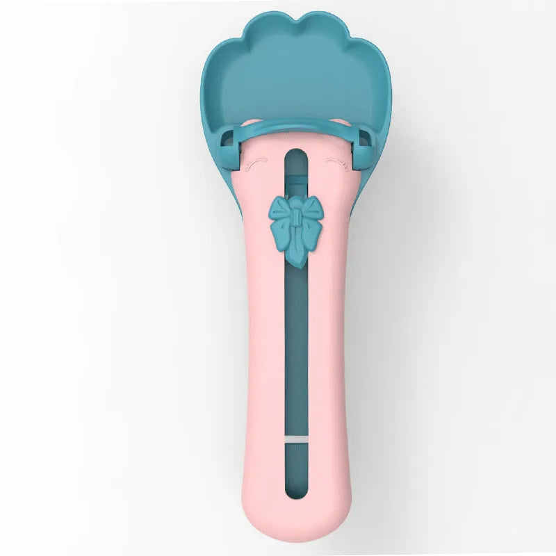 Green and pink pet feed spoon for snack extrusion and cereal dispensing with squeezer feeder design