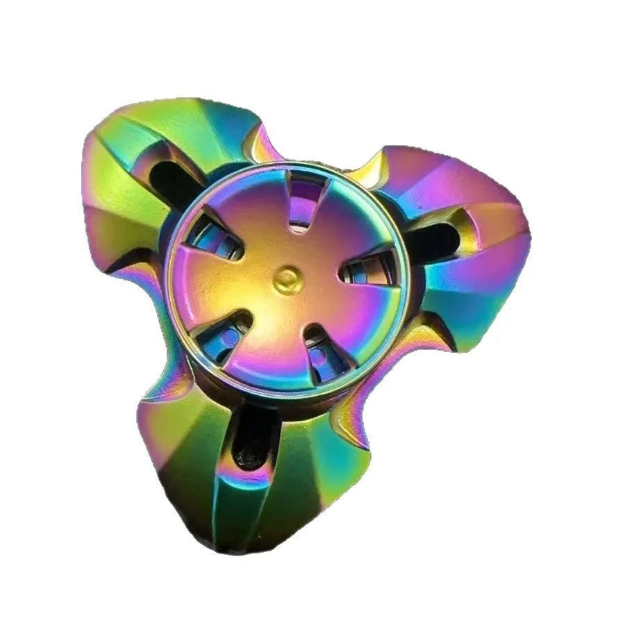 Close-up of a metallic alloy rotating fingertip gyro decompression toy on a table.