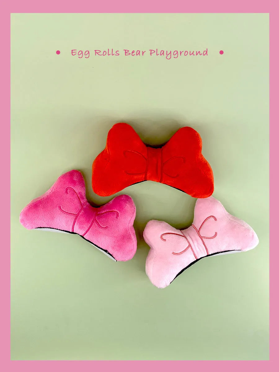 Soft plush hair-tie bow decoration for helmets in red, peach pink and rose pink.
