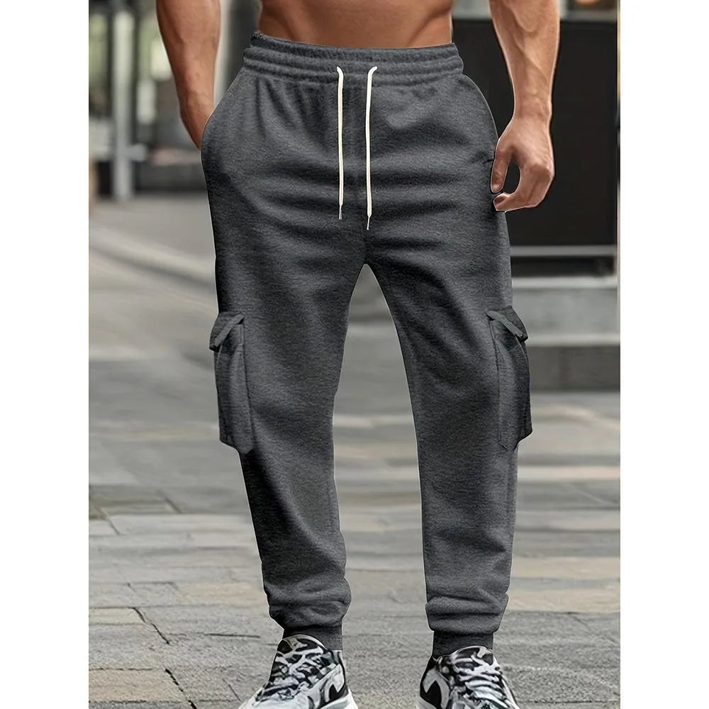 Men's solid colour casual multi-pocket drawstring sports pants in black, featuring polyester fabric and mid-waist design
