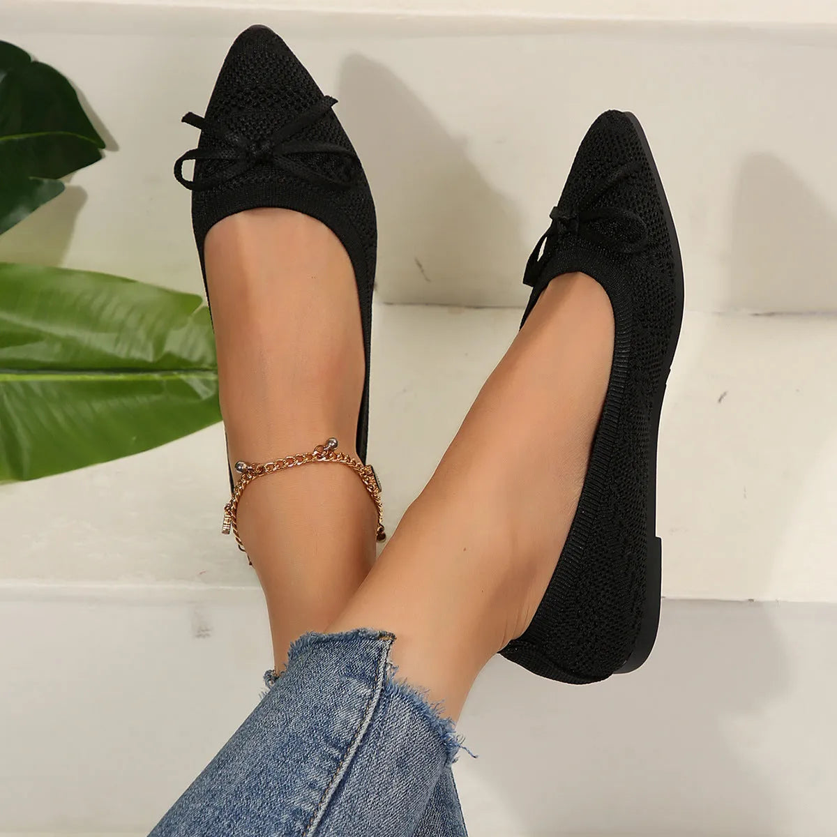 Women's blue knitted loafers with a bow and pointed toe on a flat rubber sole.