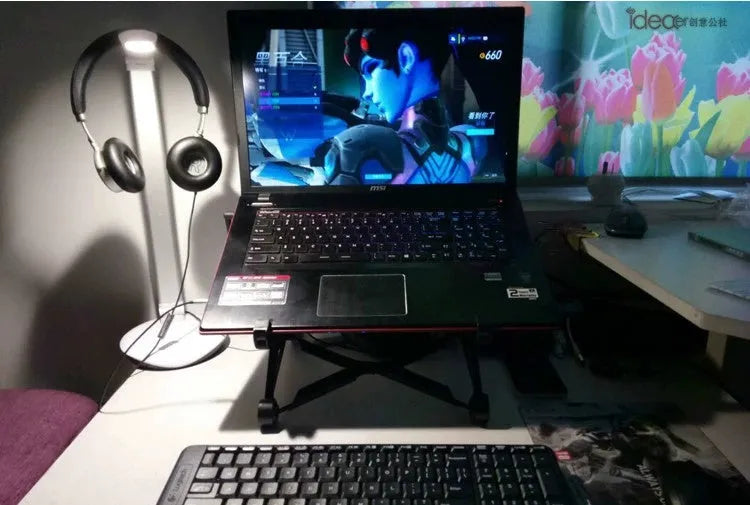 Sagacious black foldable laptop stand with enhanced nylon construction on desk