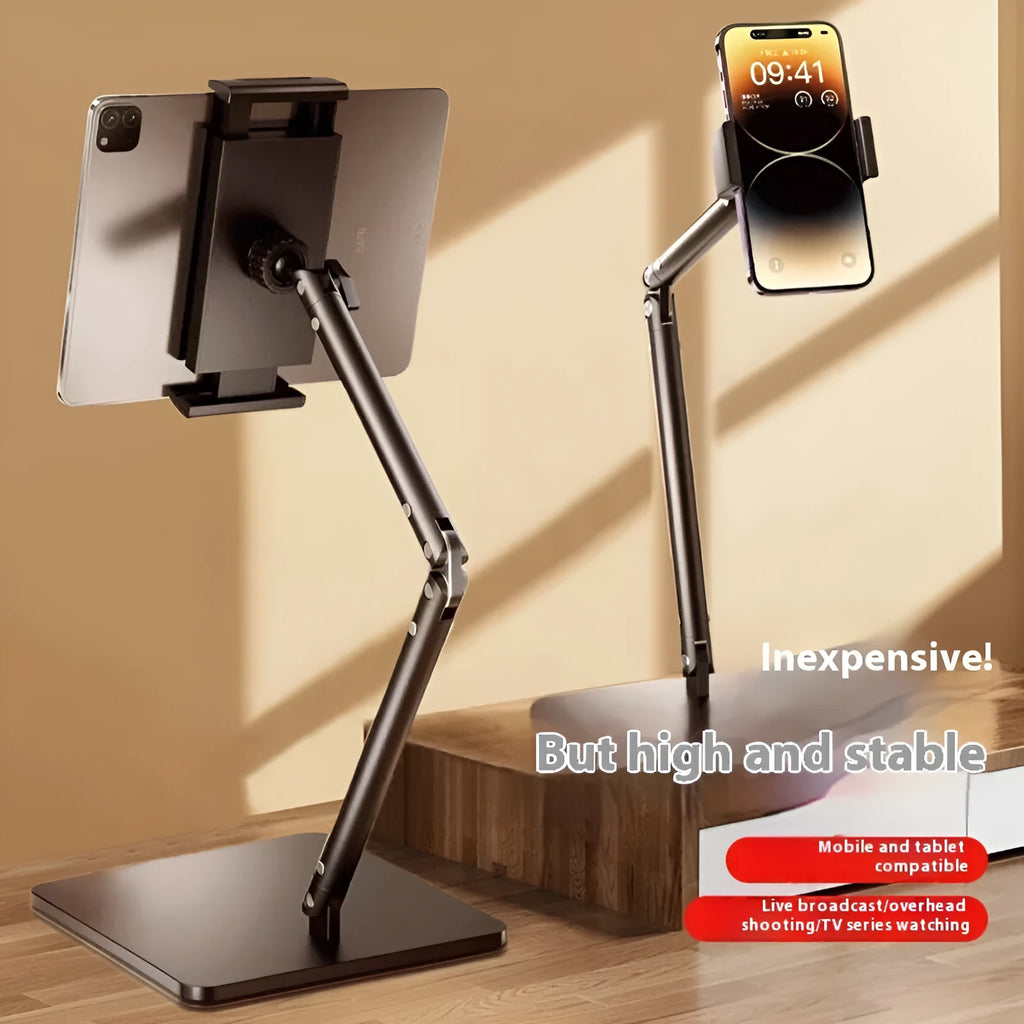 Silver alloy desktop phone and tablet bracket with double adjustable arms and a remote control on a wooden desk.