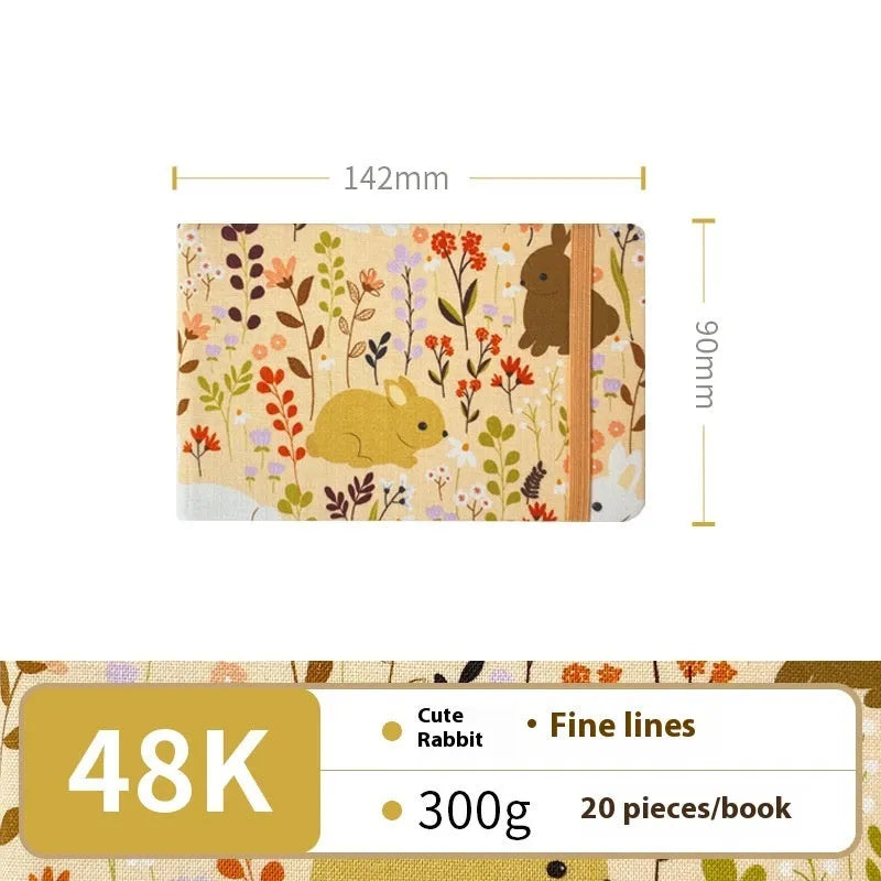 Feiluniao handmade fabric watercolour notebook with illustrated cover, open to show blank paper pages.