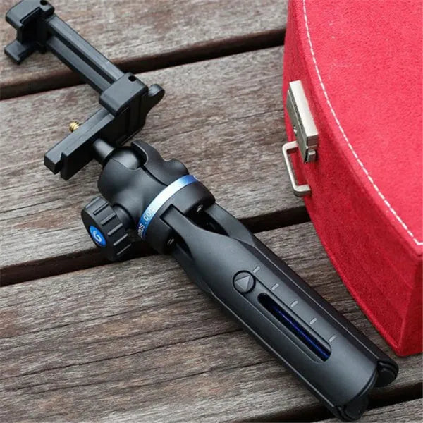 Black plastic and aluminium desktop tripod holding a mobile phone for video calls.