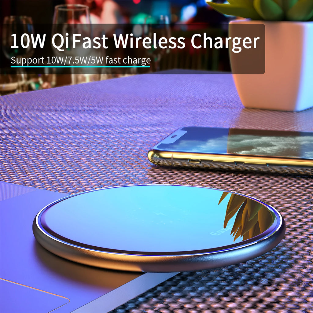 Black Qi wireless charging pad on a desk with blue LED light indicating active charging.