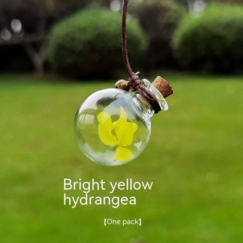 Glass car perfume pendant with preserved flower decoration hanging in car interior