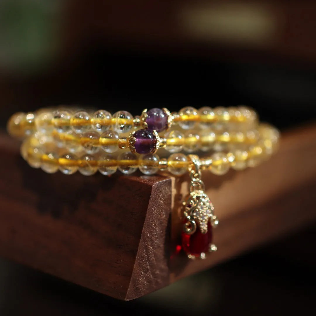 Natural gold rutilated quartz bracelet with three-circle gold and ruby bead design